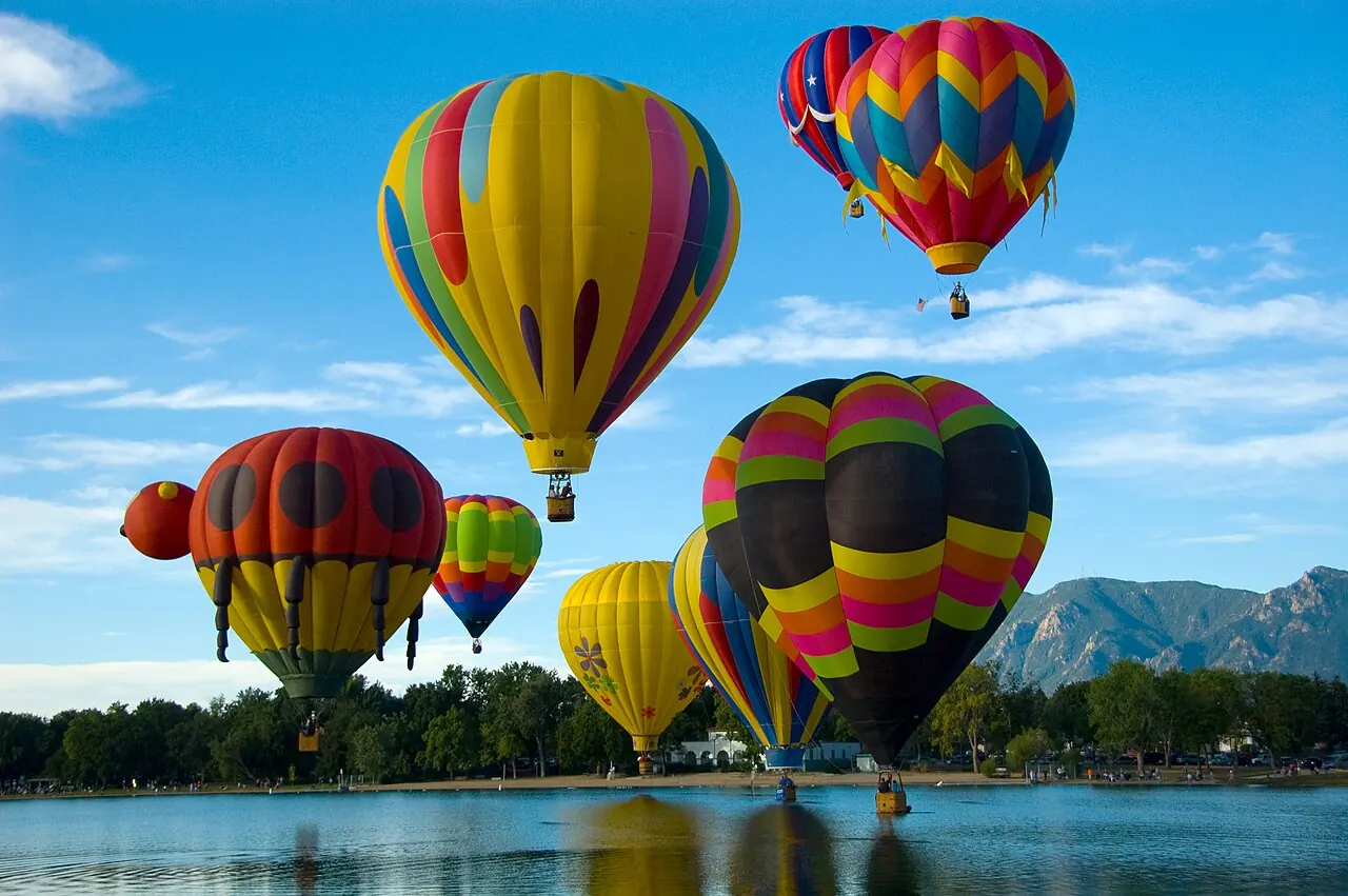 Hot air balloons lifting off in Colorado Springs with the mountains behind