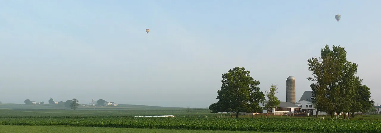 A hot air balloon over farmland and silos in Lancaster County, Pennsylvania