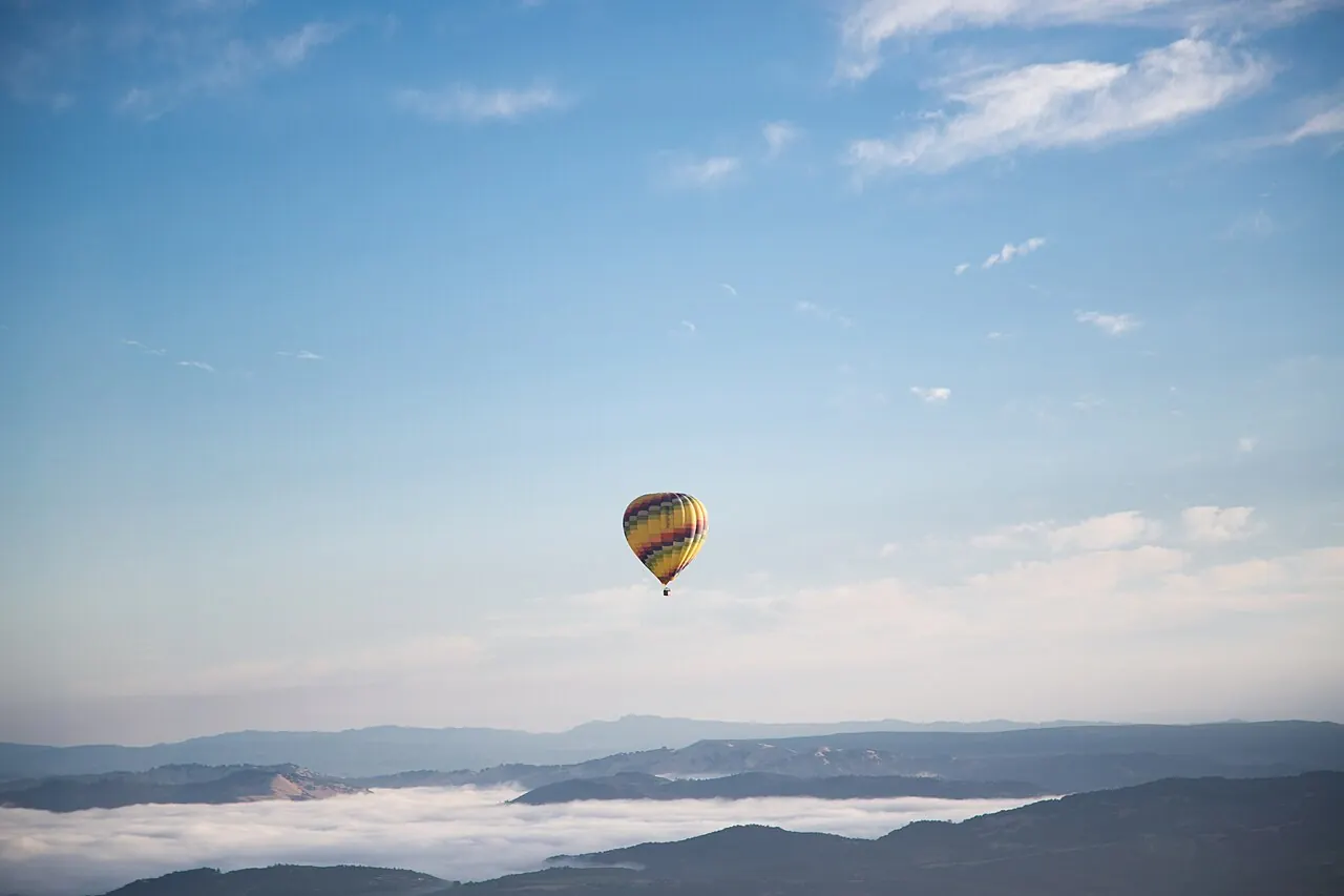 A hot air balloon high above morning haze in Napa Valley